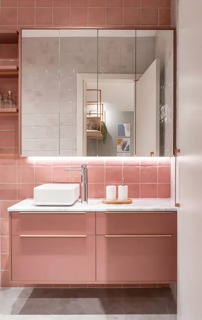 Banheiro planejado em rosa com bancada e espelheira