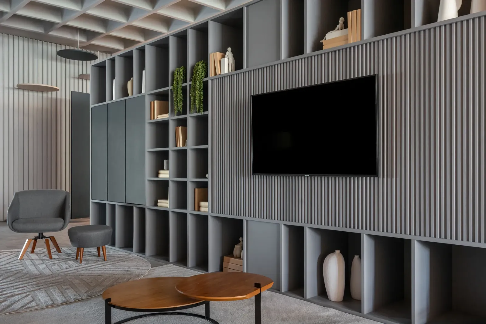 Sala planejada com painel ripado, estante e nichos
